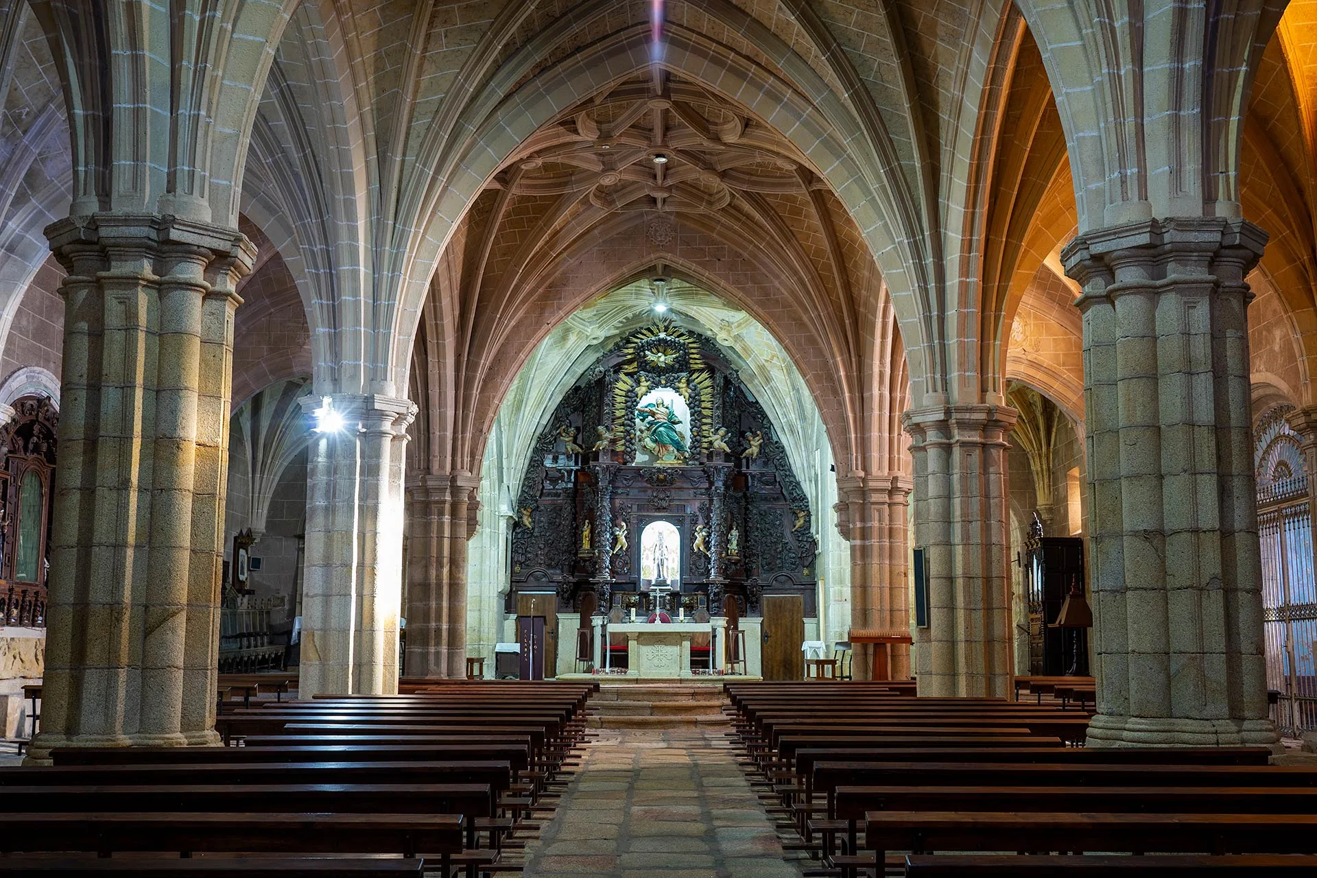 Interior de Rocamador con bóvedas de crucería y retablo al fondo