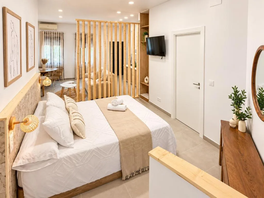 Dormitorio con cama doble y separación de madera del Estudio Don Pedro II Bajo