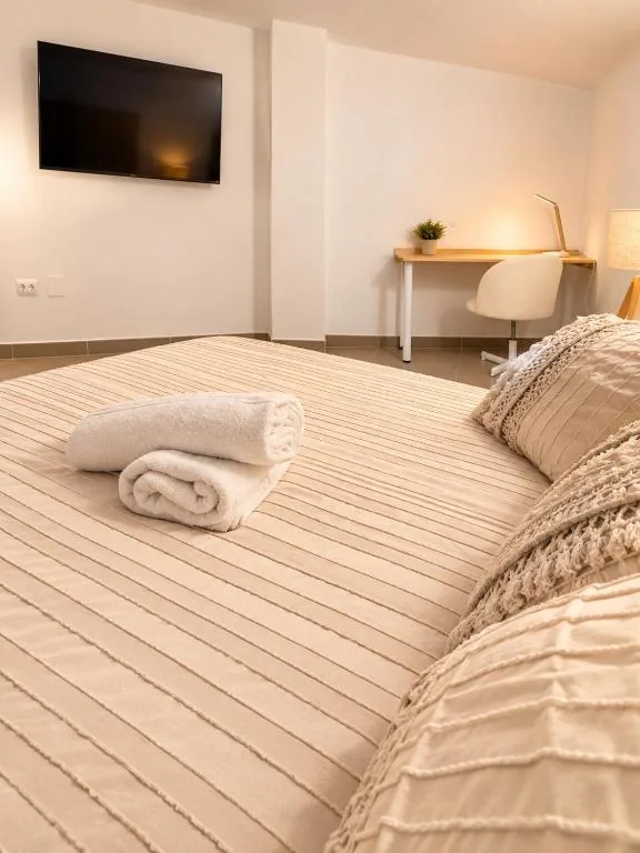 Dormitorio con cama doble, televisión y escritorio del Estudio Don Pedro II Bajo